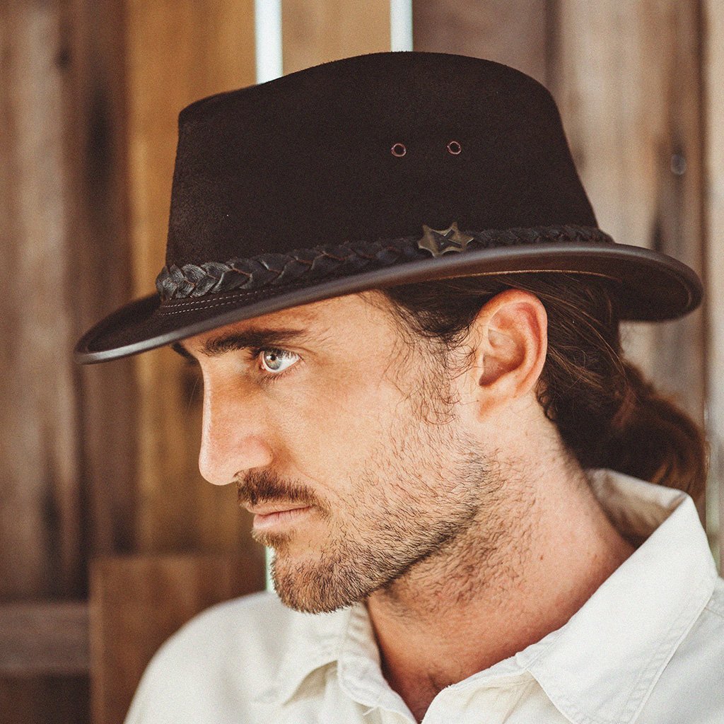 Man outside a barn door in Leather Fedora hat made by BC Hats in color Black