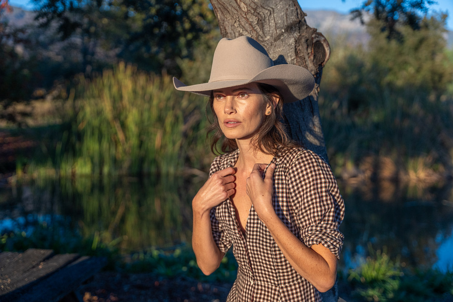 A diverse group wearing eco-friendly cowboy hats from Conner Hats in a lush outdoor setting, engaged in activities like hiking and boating.