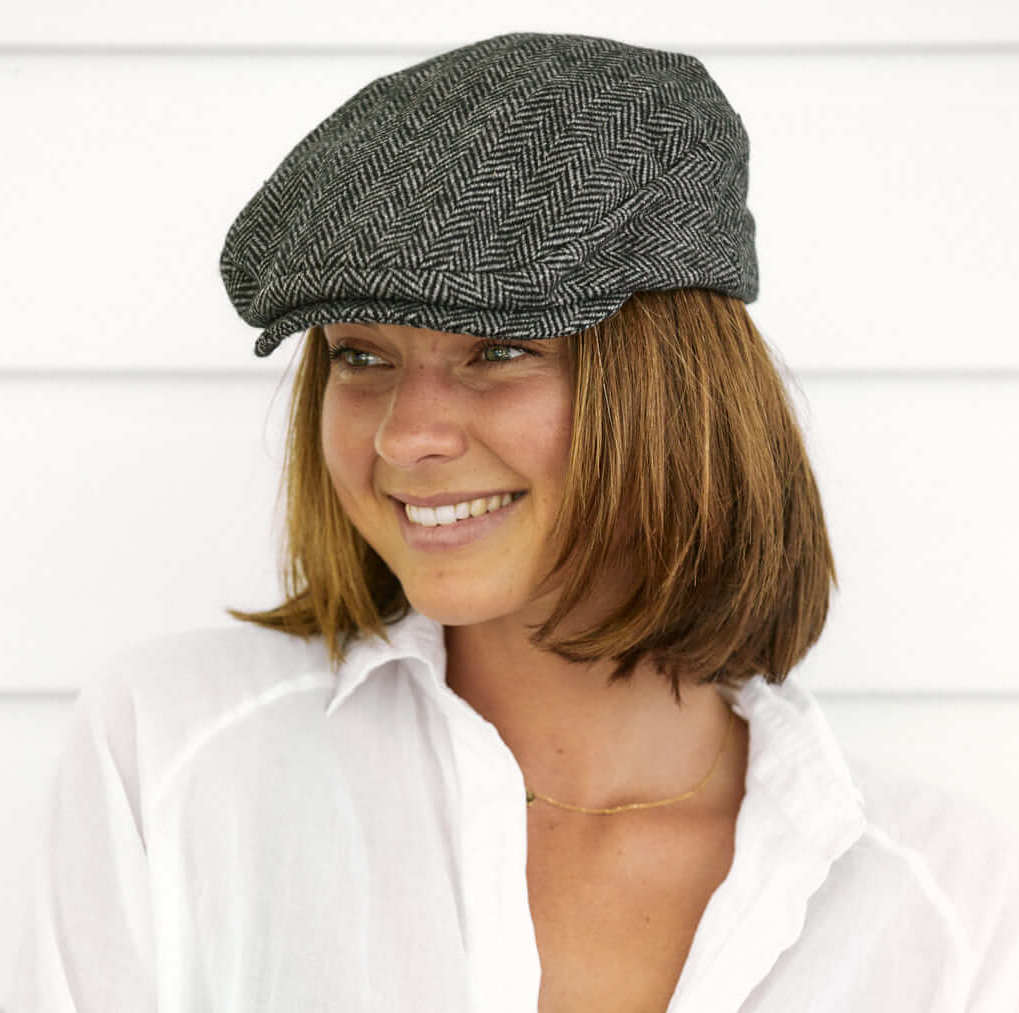 Woman wearing grey houndstooth newsboy cap by Conner hats