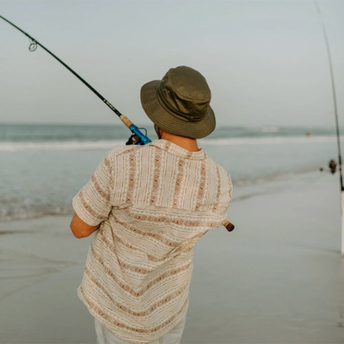 Man catching a fish wearing organic cotton bucket hat