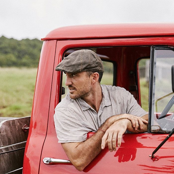 Man in Newsboy cap in a truck