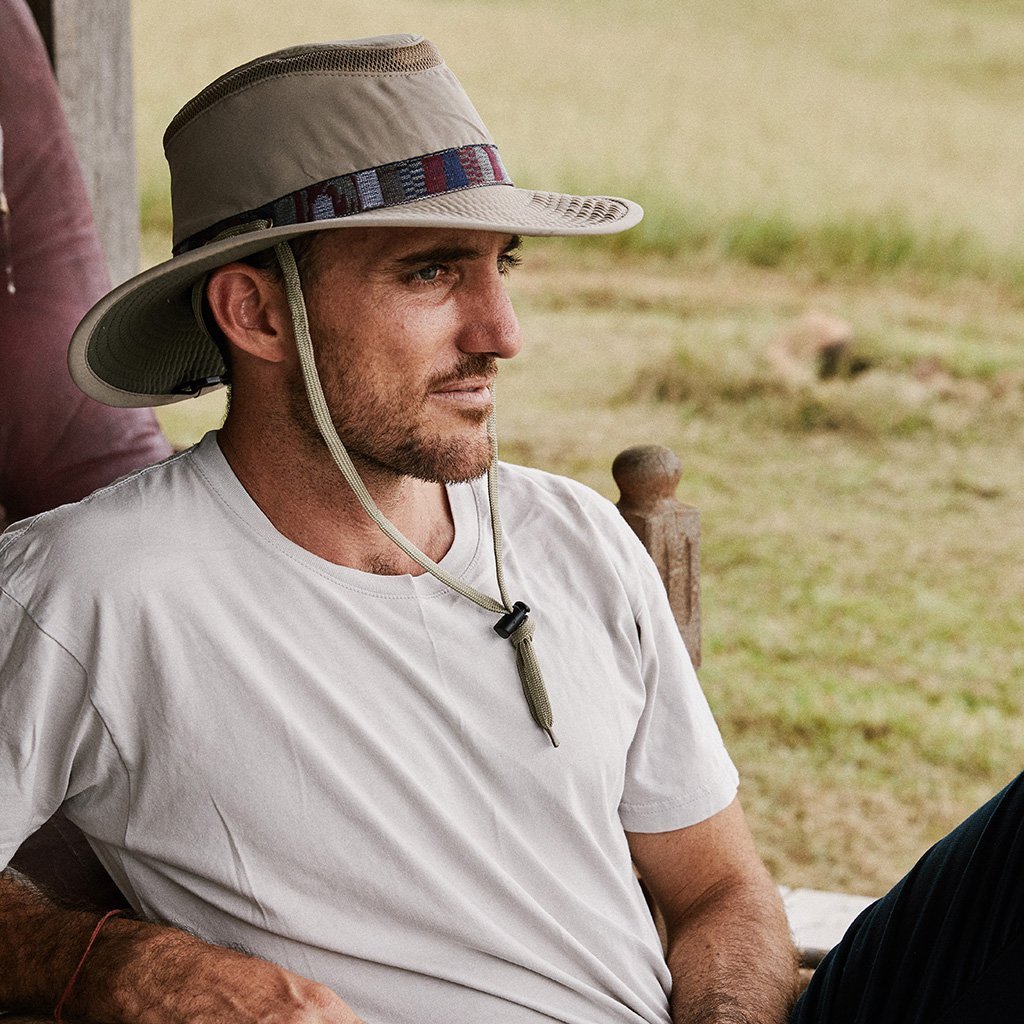 Man sitting outside wearing cloth recycled boating sailing hat in color Sand showing chin cord