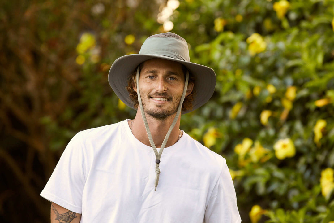 Man wearing Olive colored recycled cloth boating sailing hat Hat that floats and has a sun protective ventilation system and secure chin cord for hands free work