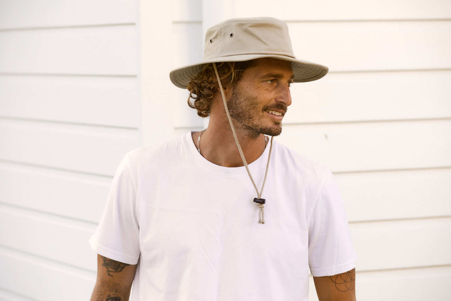 Man smiling in a Boonie bucket style hat made from organic cotton with wide sun protective brim and cotton chin cord