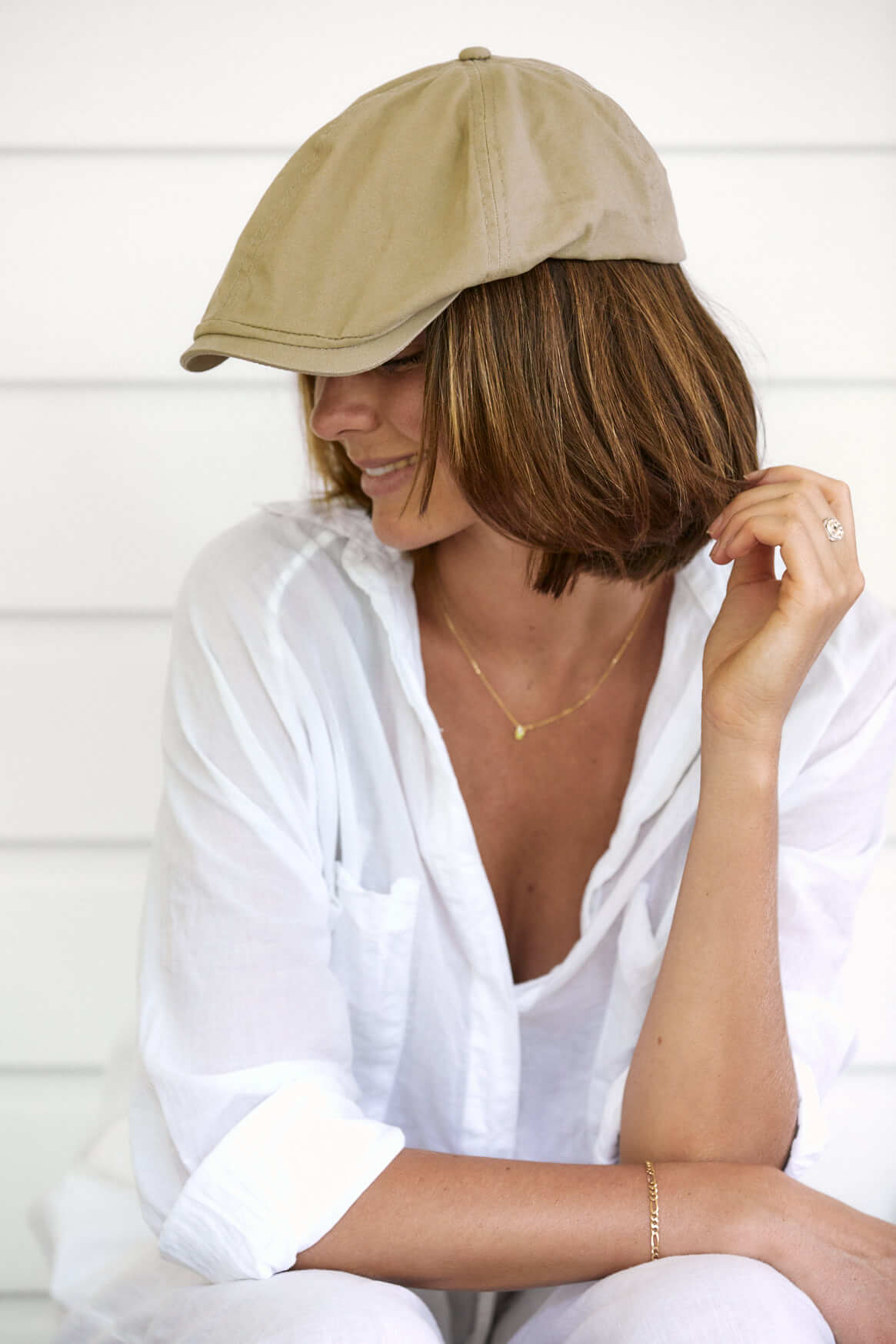 Woman sitting showing profile of Conner hats organic cotton newsboy golf hat in color Khaki