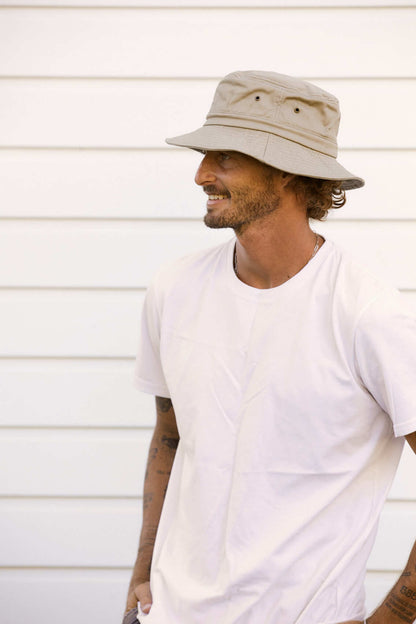 Man smiling and wearing Conner Hats organic cotton cloth bucket hiking hat in color Khaki 