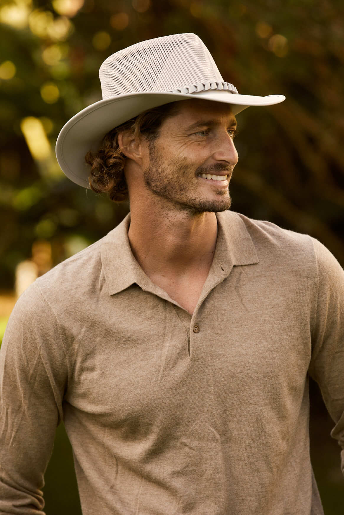 Man smiling outside in Aussie outback soakable golf hat showing mesh crown and sun protective brim in color Sand