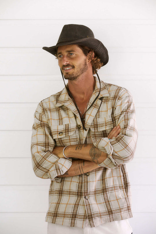 Man standing outside in outback style hat made from water proof weathered cotton that looks like leather