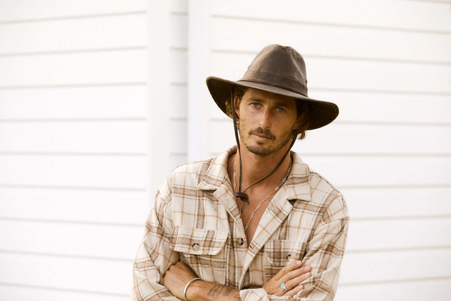 Man in plaid shirt wearing wide brim sun protection cloth outback outdoor hat with chin cord