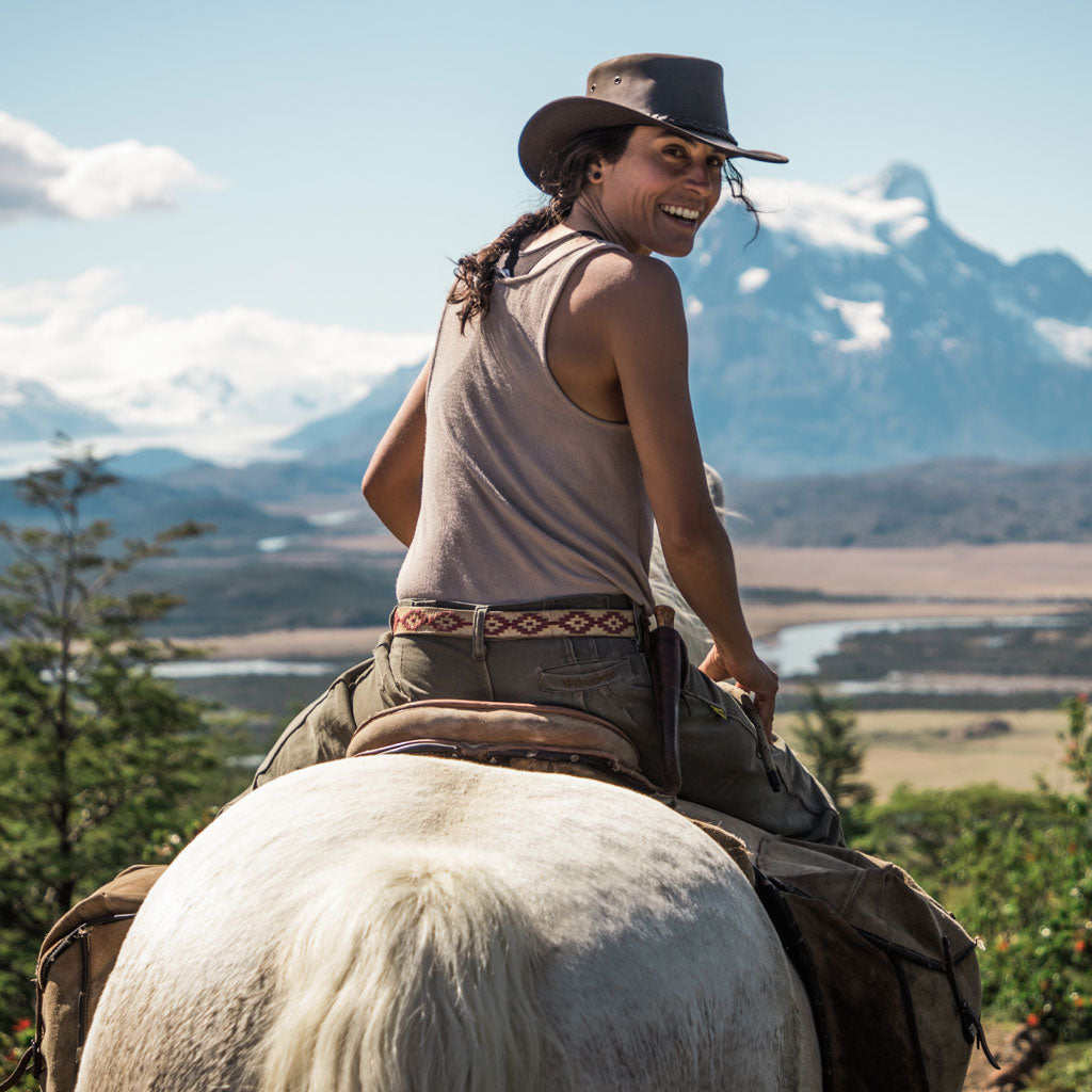 Woman riding a horse wearing leather outback crushable hat with wide brim  in color Brown