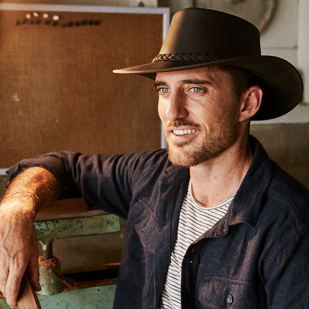 Man in workshop wearing leather outback crushable hat with wide brim  in color Brown