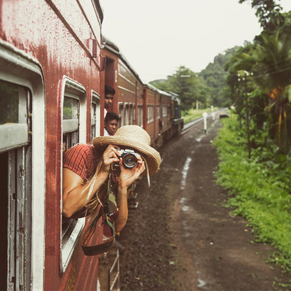 Girl taking photo outside a train window wearing ladies raffia straw gardening Hat with Brown leather chin cord