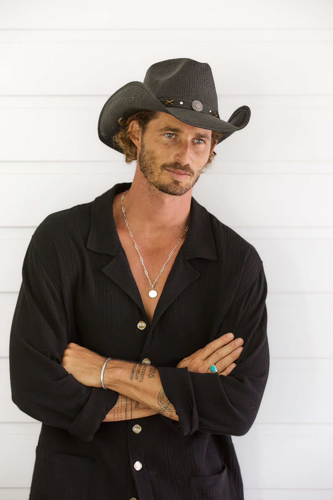 Man wearing western straw hat in color Black with silver conch and faux leather band