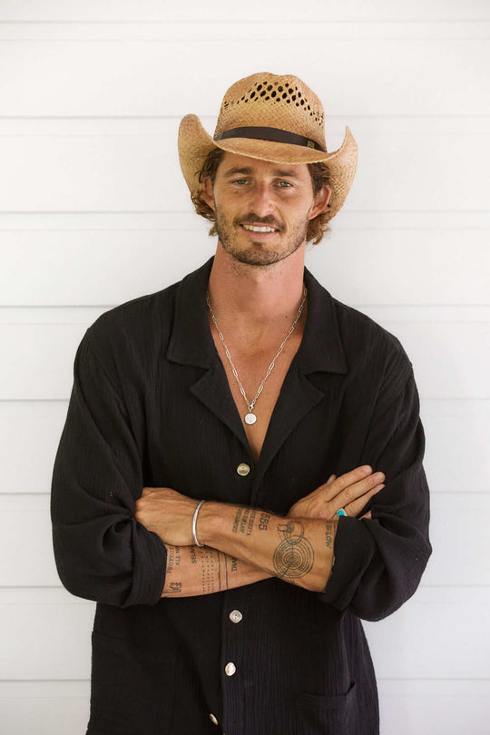 Man in Black shirt wearing western straw hat with vented crown and route 66 logo on vegan hat band