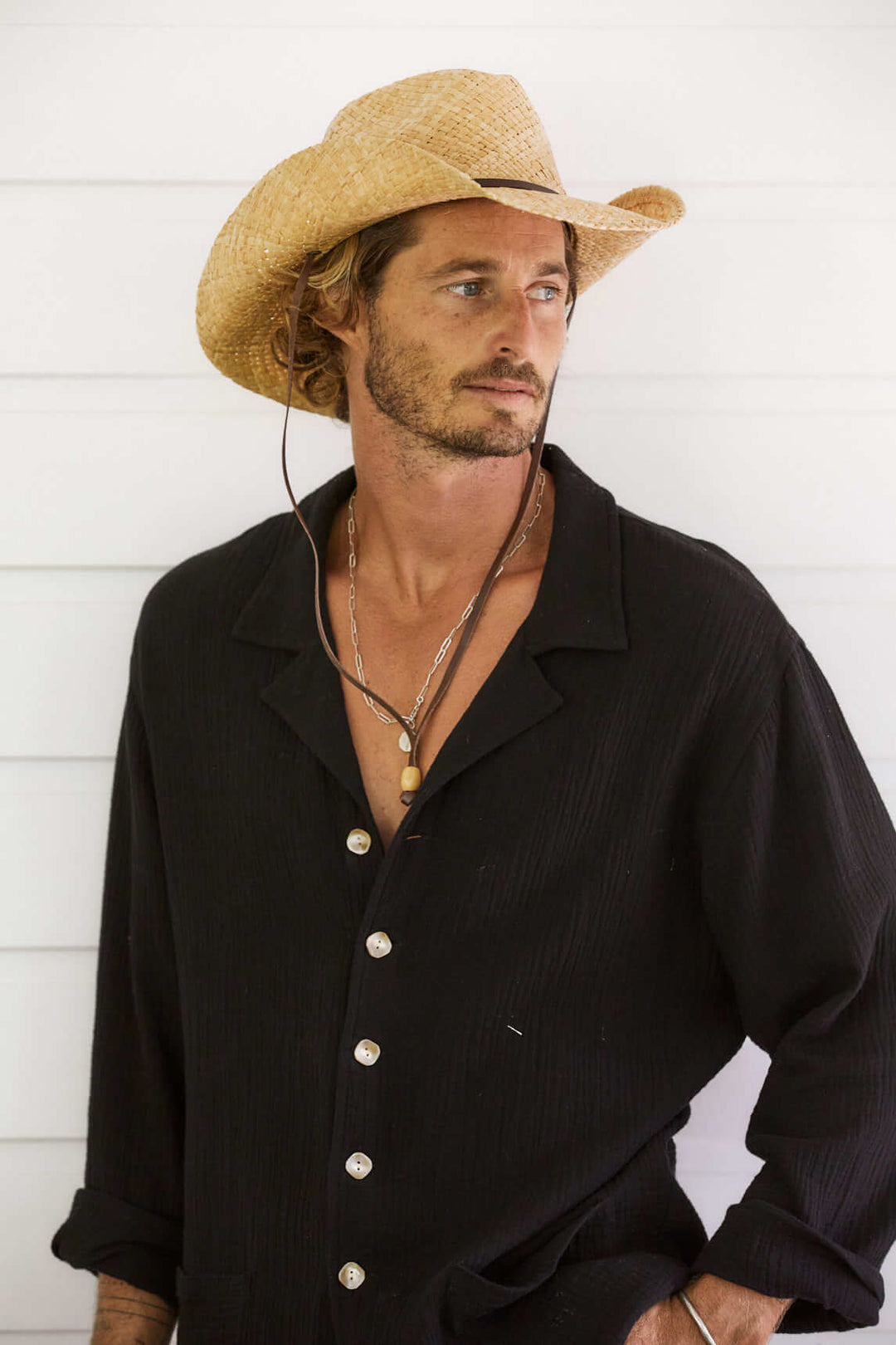 Man wearing the Conner Hats Original western raffia hand braided straw western hat with a leather chin cord