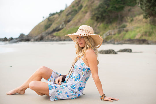 Sitting on the beach in Women's raffia straw wide brim hand crocheted summer hat with an open weave vent in crown and edge