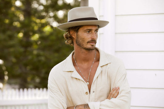 Man standing outside in wool fedora hat in color Putty with bound edge and grosgrain band