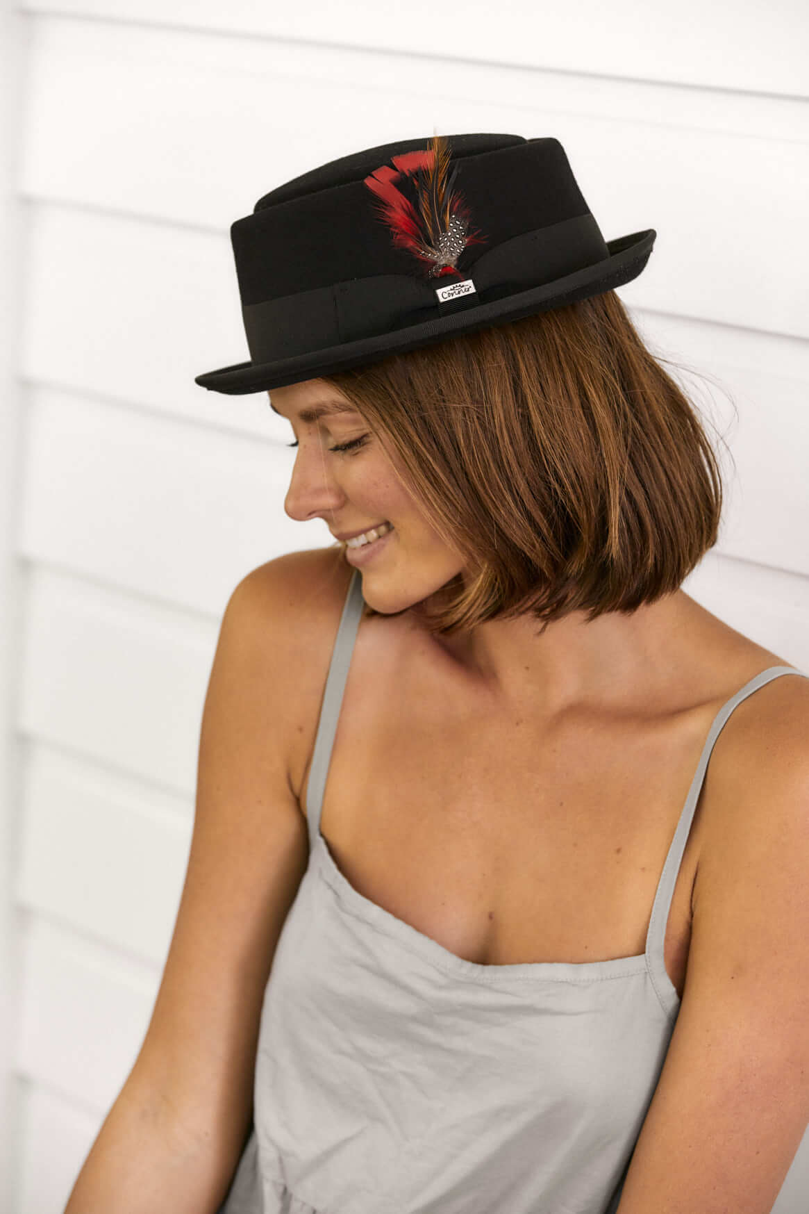 Woman wearing wool porkpie fedora hat in color Black with feather accent