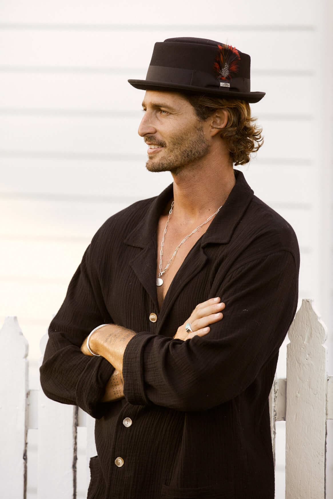 Man wearing Mumford porkpie fedora wool hat in color Black with feather accent