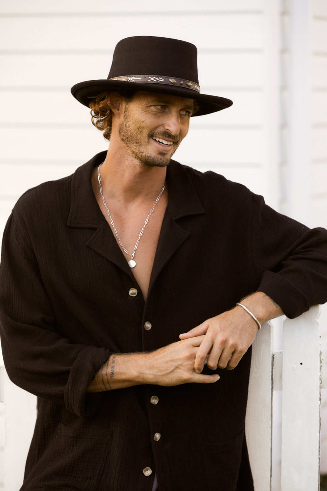 Man in wool gambler shaped hat in color Black with leather band featuring accented stitching and diamond shaped dull brass studs