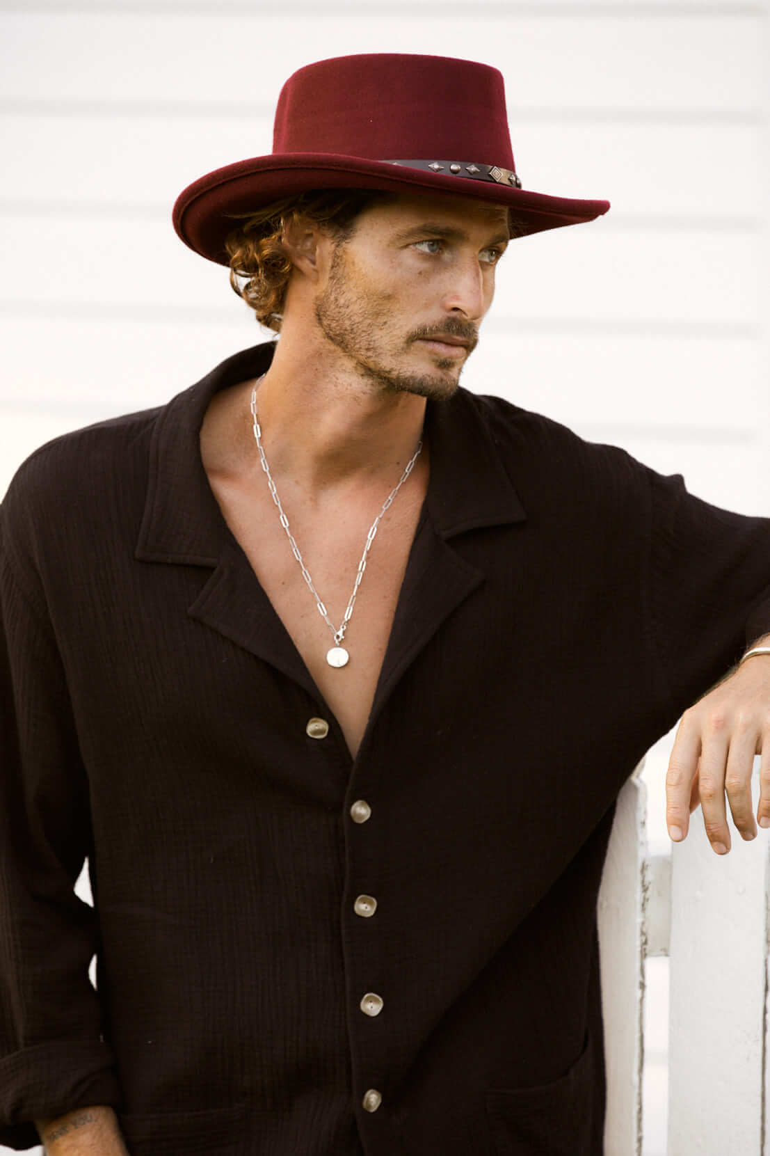 Man wearing Burgundy wool gambler hat with vegan band with silver colored studs