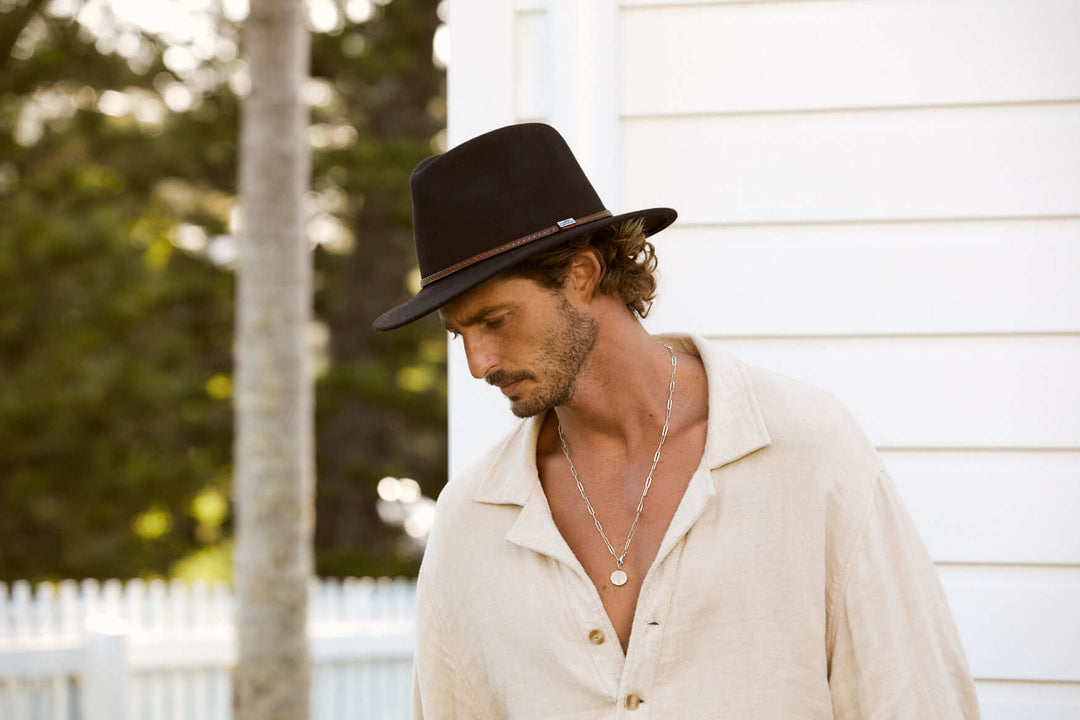 Man outside in Brown wool outback hat with thin tooled leather hat band and Conner emblem