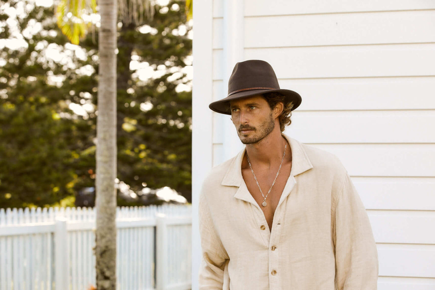 Man outside showing front view of Brown wool outback hat with thin tooled leather hat band 