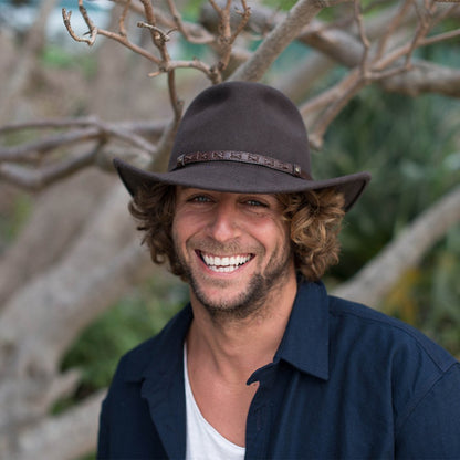 Man smiling outside wearing Conner hats Crossroads outback crushable waterproof Black colored wool hat with Brown faux leather band