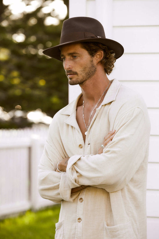 Man outdoors wearing Conner Hats Indiana Jones outback wool fedora hat with grosgrain band and trim