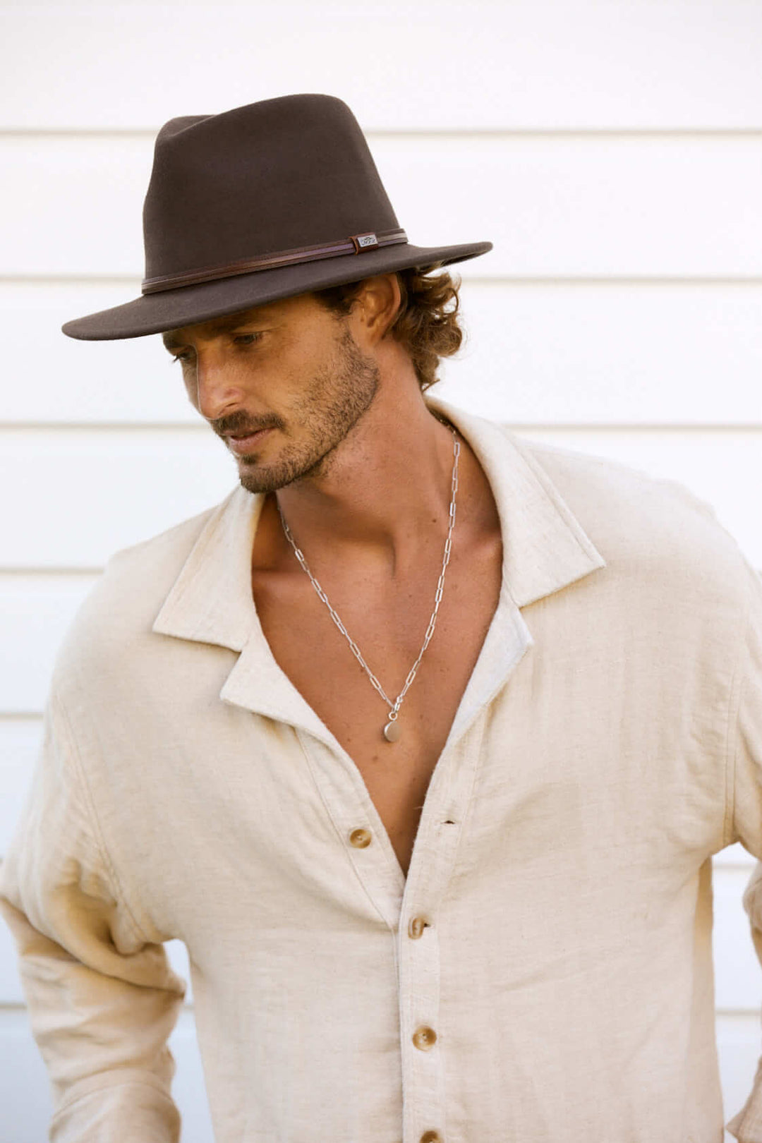 Man outside looking stylish wearing Conner Hats Jackeroo crushawool outback Australian style Hat in color Brown with smooth leather hat band and Conner Emblem