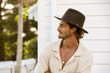 Man in profile view outside wearing Conner Hats Jackeroo crushawool outback Australian style Hat in color Brown with smooth leather hat band and Conner Emblem