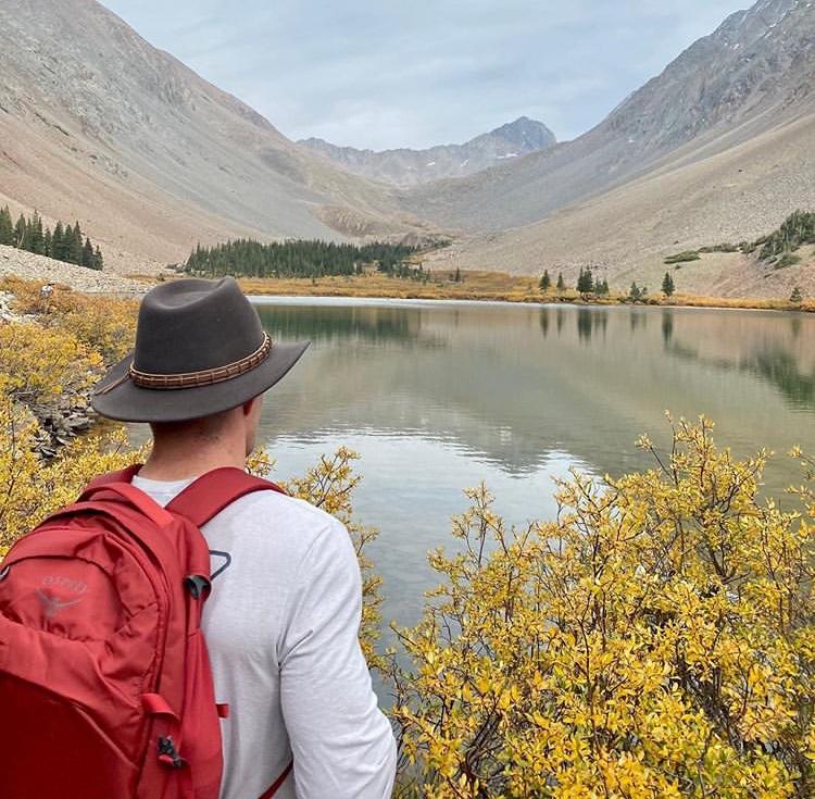 Man looking out over a lake wearing Brown colored Wide Open Spaces Outdoor Hat