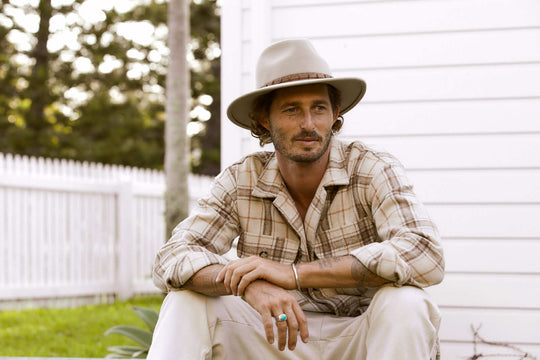 Man sitting outside wearing outback wool hat in color Putty with leather hat band 