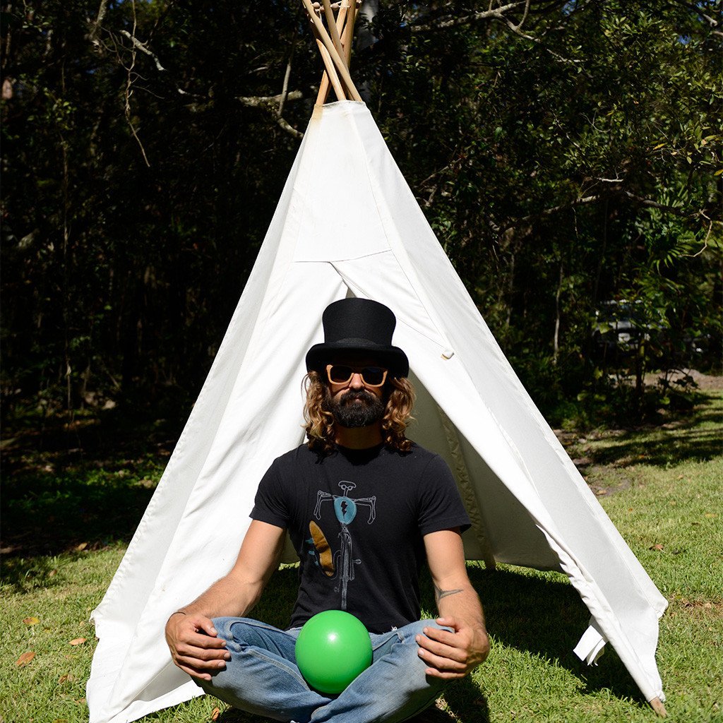 Man wearing wool top hat by Conner Hats sitting outside a Tee Pee