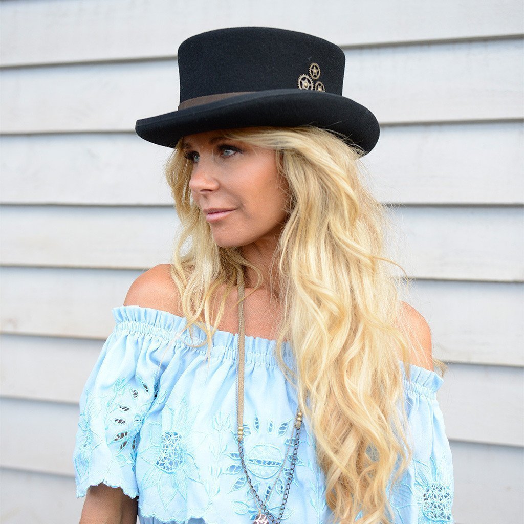 Woman wearing Steampunk style short wool top hat with brass colored gears and leather hat band