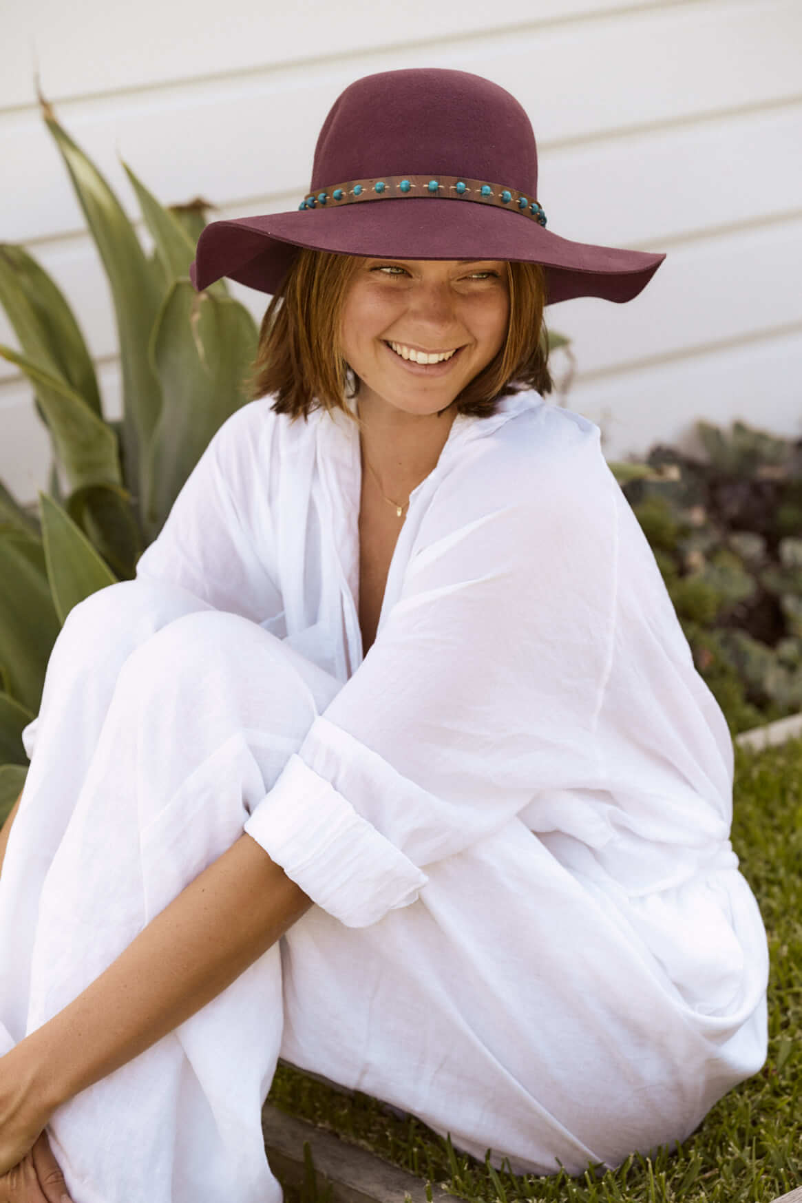 girl sitting on grass smiling in Plum colored Women's Wool floppy boho Hat 